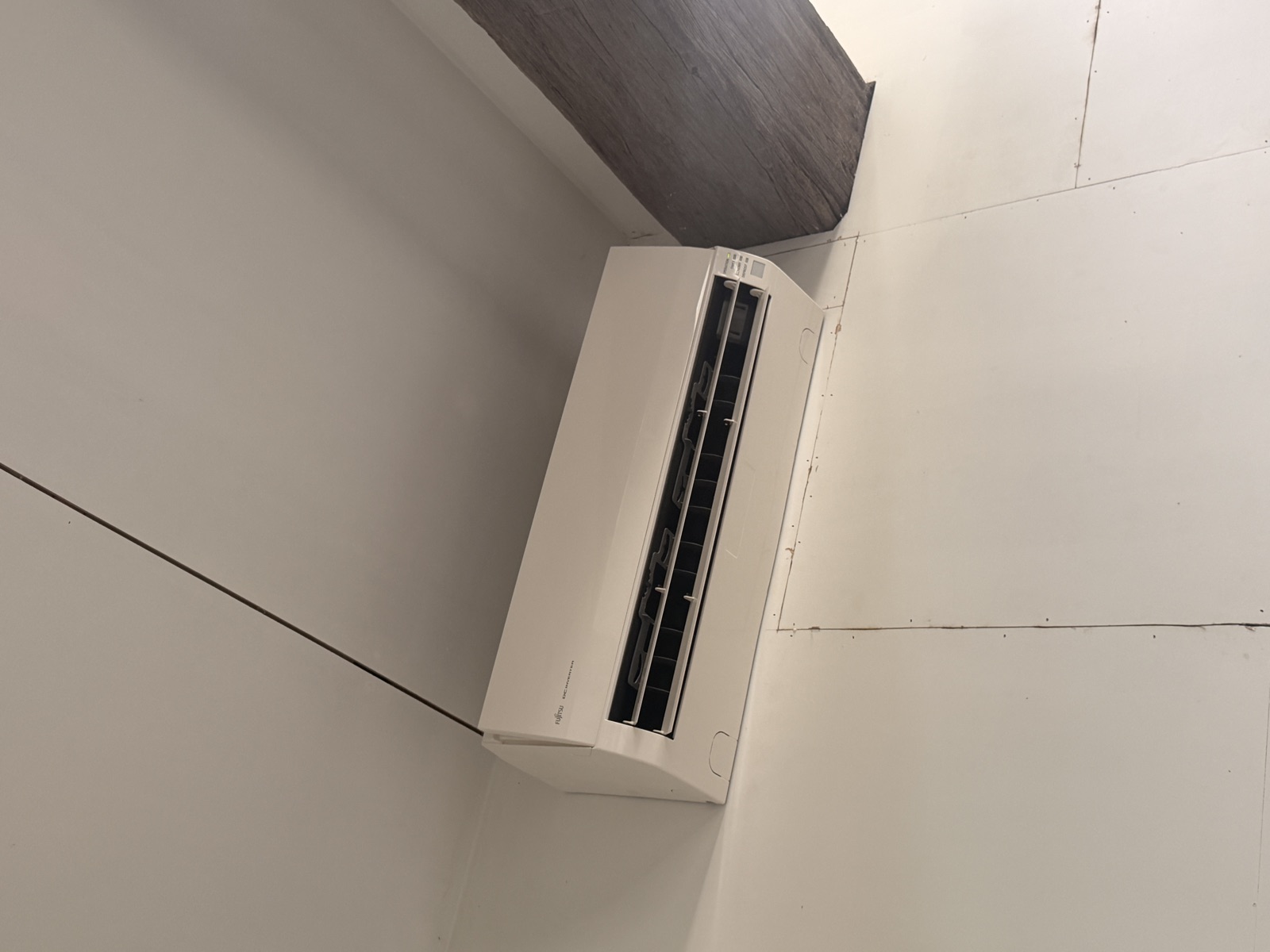 Cleaned Fujitsu high-wall heat pump reassembled on the wall and running again